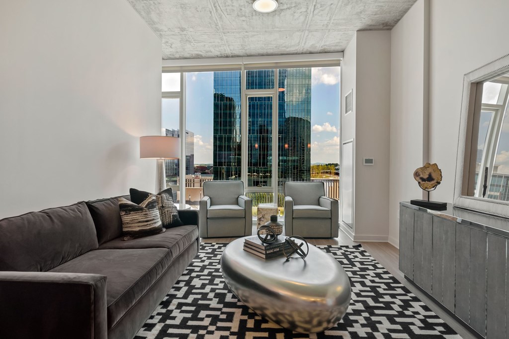 a living room with a couch and a large window with a city view