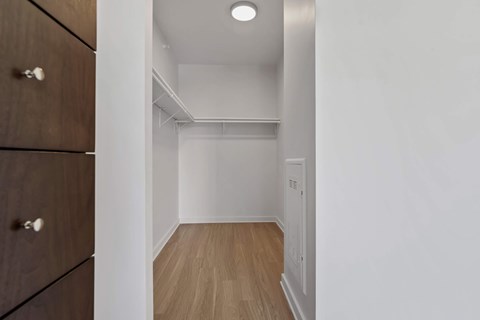 a bedroom with white walls and a closet and a wood floor