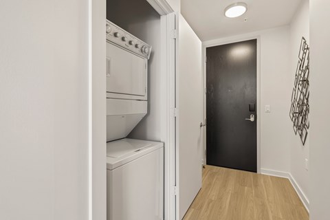 a laundry room with a washer and dryer and a black door