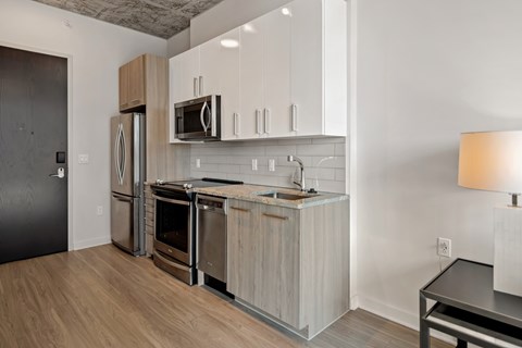 a kitchen with white cabinets and stainless steel appliances and a refrigerator