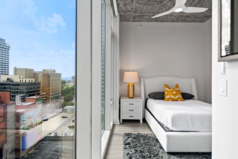 a bedroom with a white bed and a large window