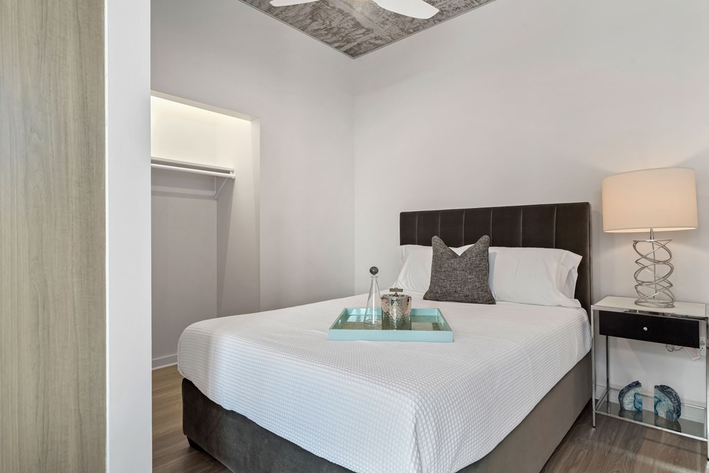 a bedroom with a large white bed and a mirrored table