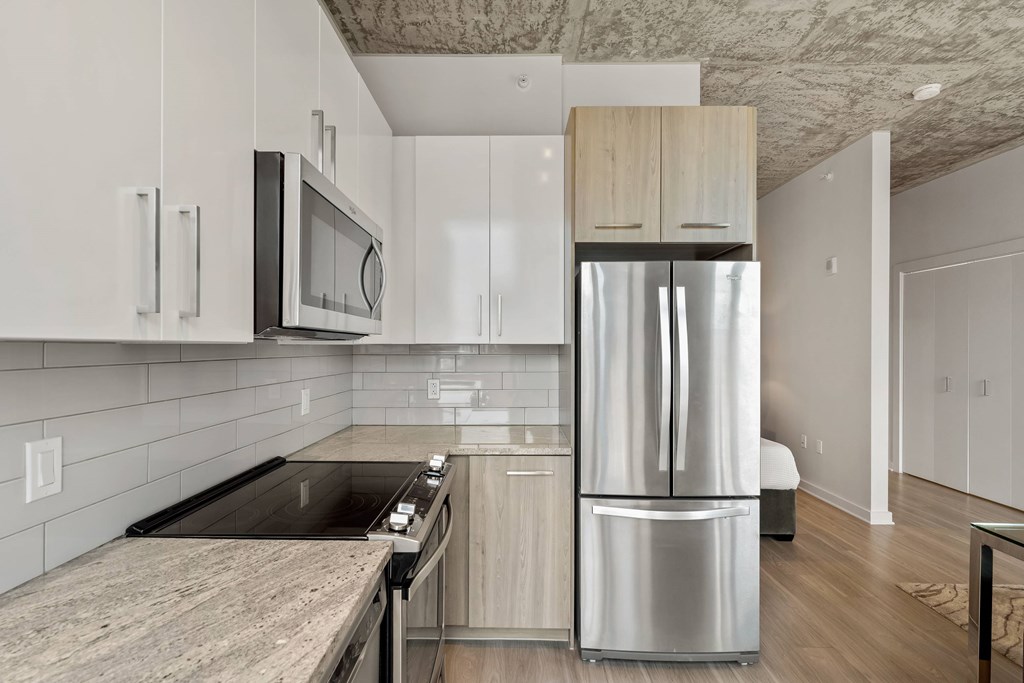 a kitchen with white cabinets and a stainless steel refrigerator