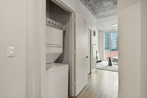 a walk in closet with a washer and dryer in a living room