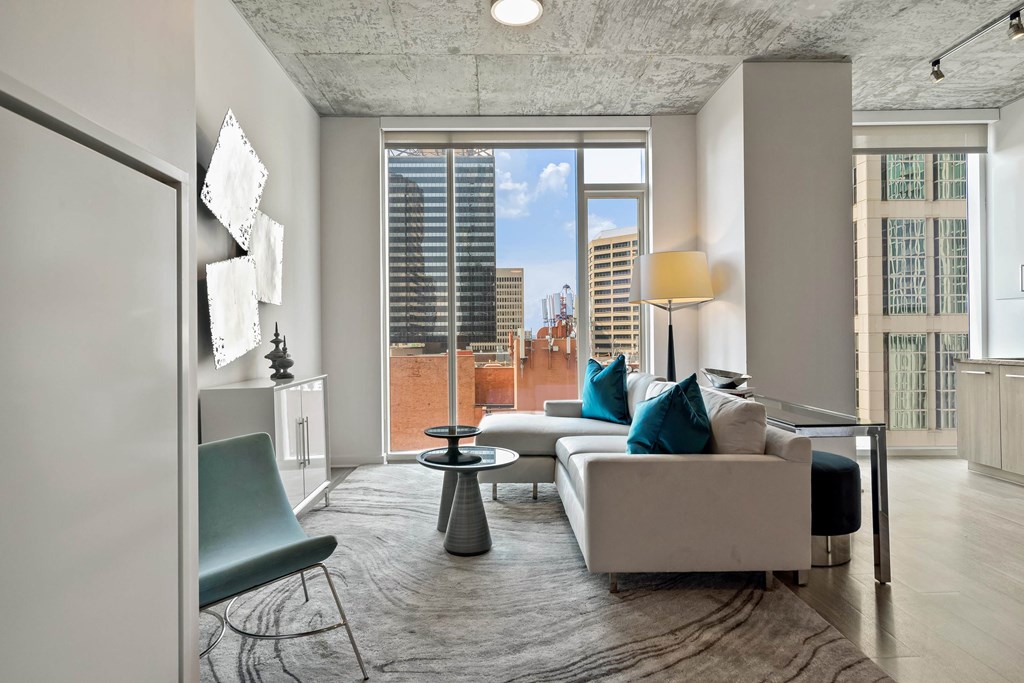 a living room with a couch and a window with a city view