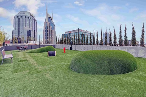 a grassy area with chairs and a red fire hydrant