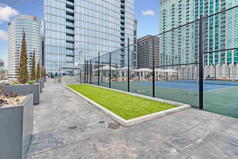 a view of a tennis court on a roof with tall buildings