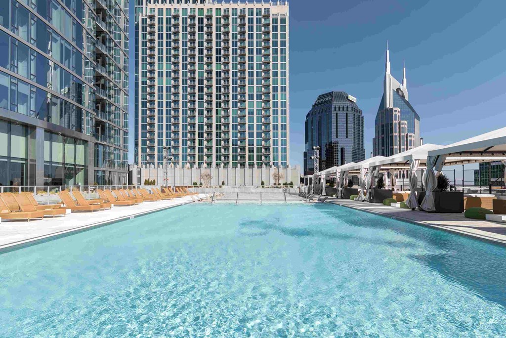 a swimming pool at a hotel with skyscrapers in the background