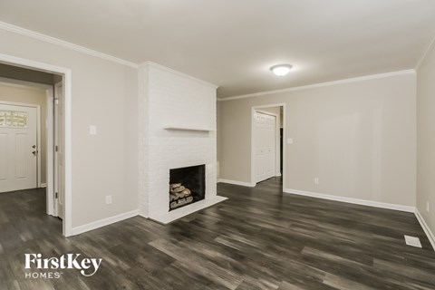 the living room has a fireplace and hardwood floors