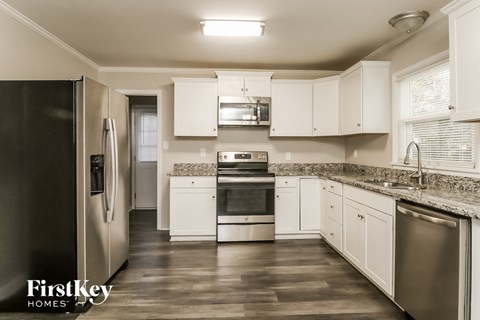 a kitchen with white cabinets and stainless steel appliances