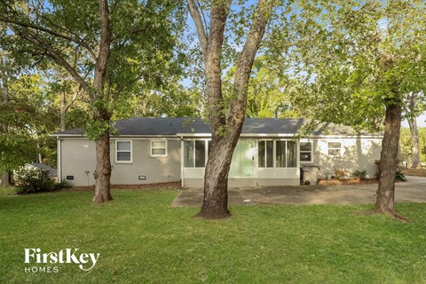 a gray house with trees in front of it