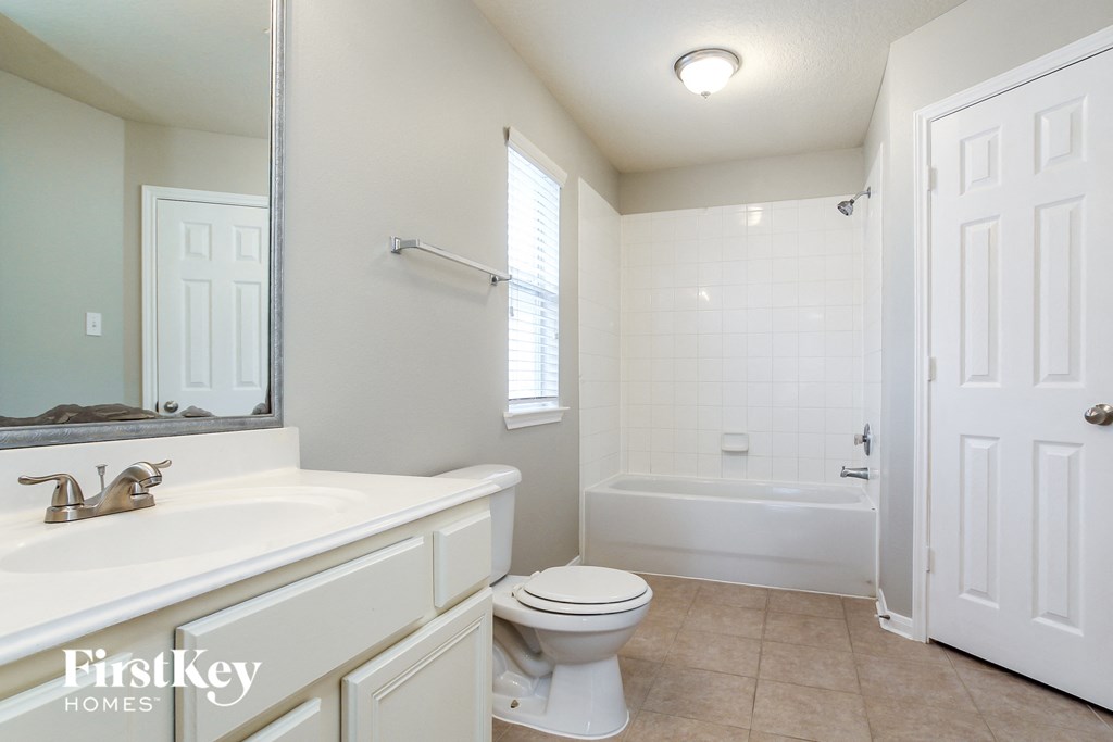 a bathroom with a toilet and a sink and a bath tub