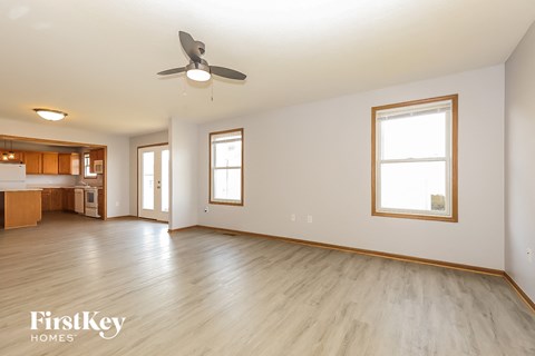 A spacious room with a ceiling fan and wooden flooring.
