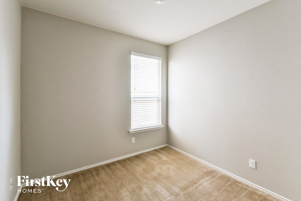 a bedroom with white walls and a window with a window sill