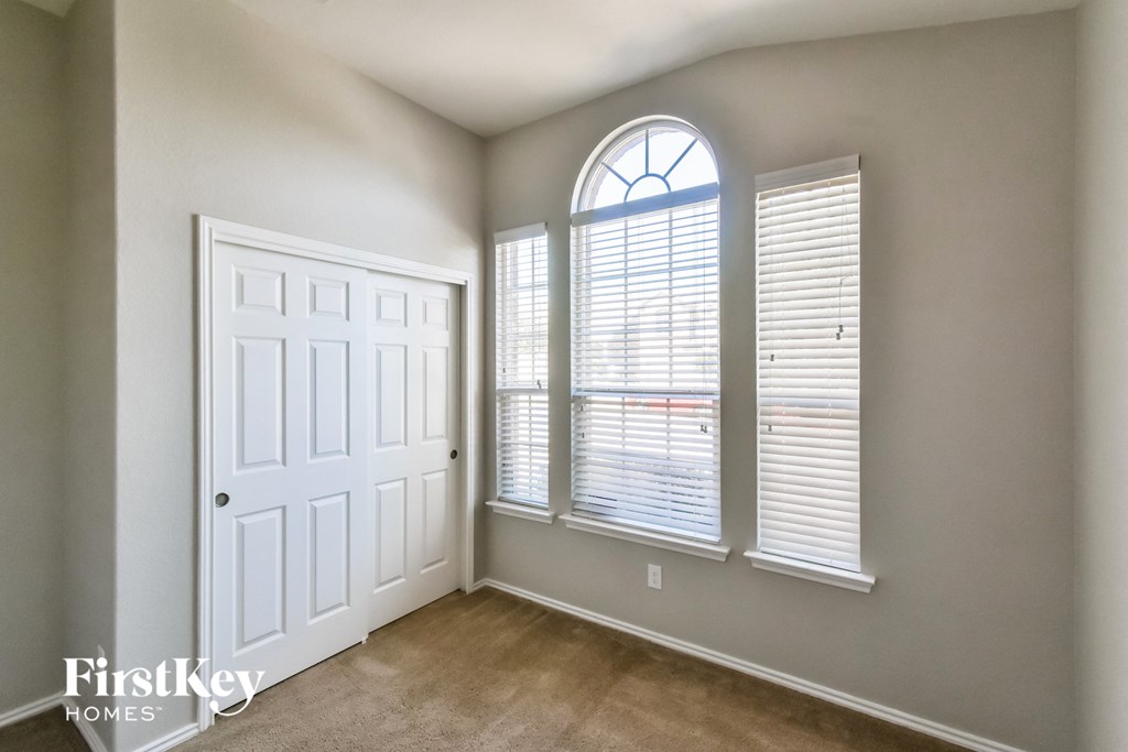 an empty living room with a large window and a white door
