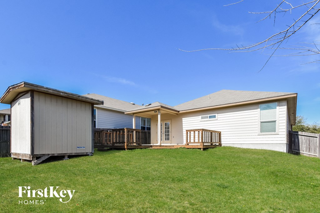 a home with a deck and a shed on the side of it