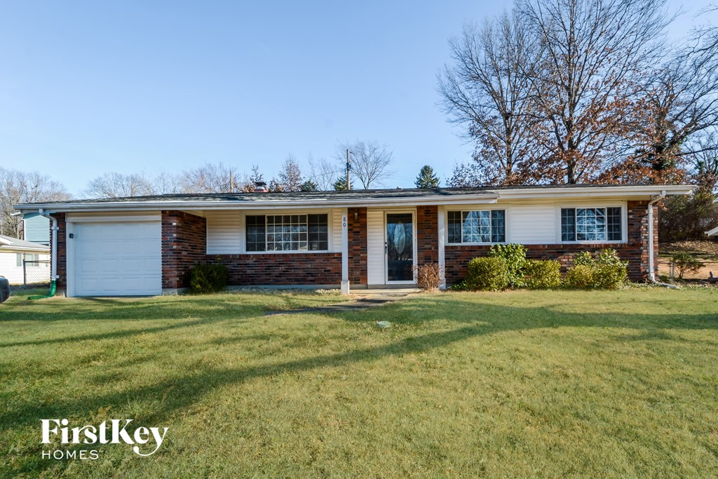 a small brick house with a lawn in front of it