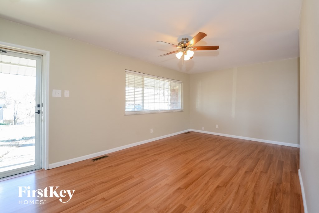 a living room with wood floors and a ceiling fan