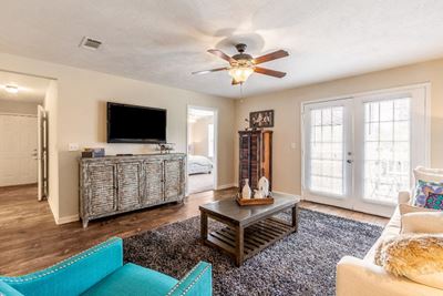 Newly renovated living room with ample seating and ceiling fan at The Reserve of Byram apartments for rent in Byram, NJ