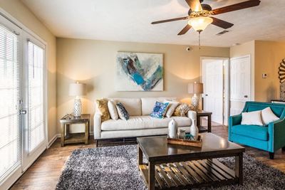 Newly renovated living room with ample seating and ceiling fan at The Reserve of Byram apartments for rent in Byram, NJ