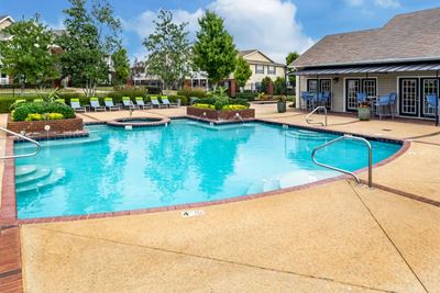 Outdoor swimming pool with lounge chairs at The Reserve of Byram apartments for rent in Byram, MS