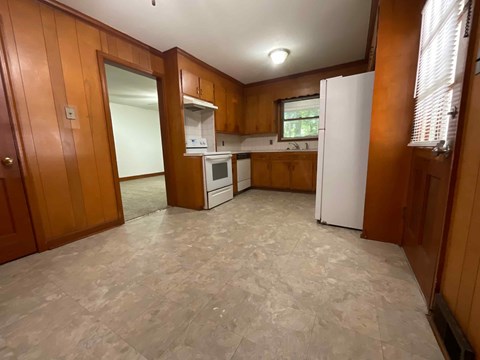 A kitchen with wooden cabinets and a white refrigerator.
