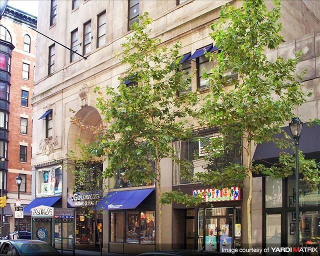a building on a city street with a tree