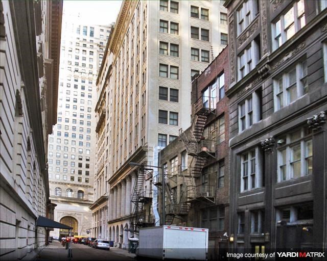 a city street with tall buildings  and a truck