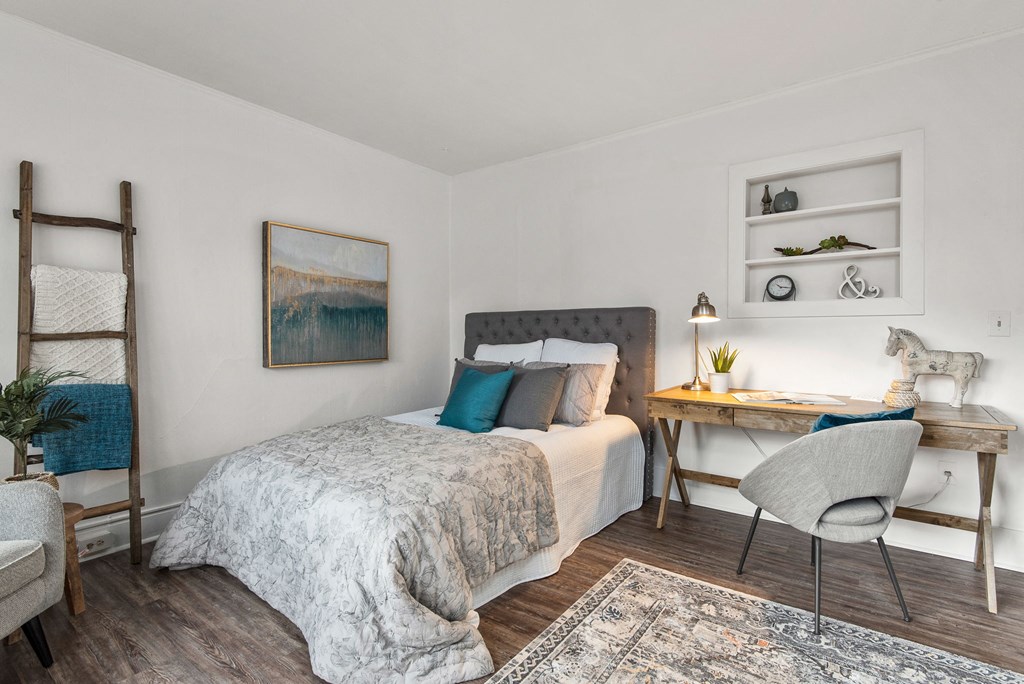 a bedroom with a bed and a desk with a chair