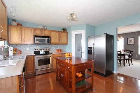 a kitchen with wooden cabinets and stainless steel appliances