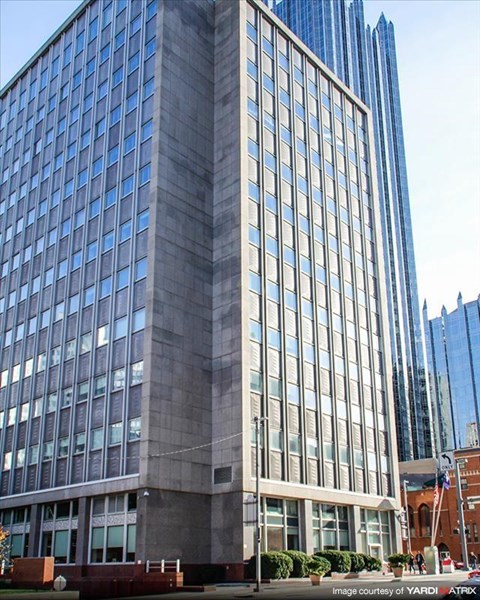 a tall building with many windows and a street in front of it