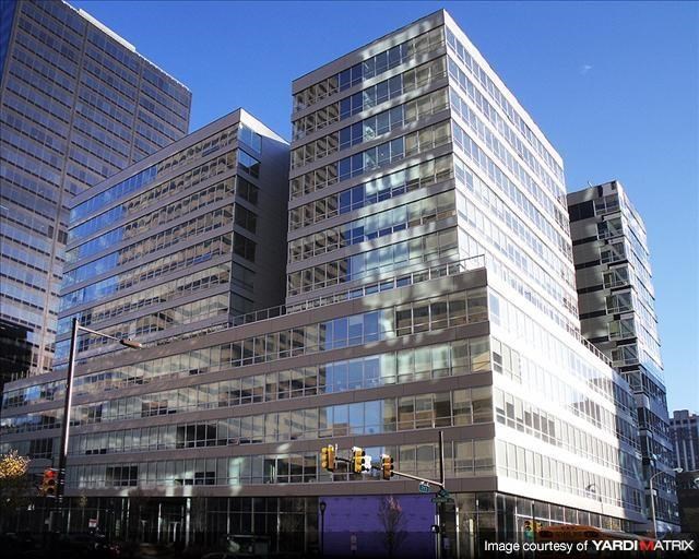 a tall building with many windows in front of other tall buildings