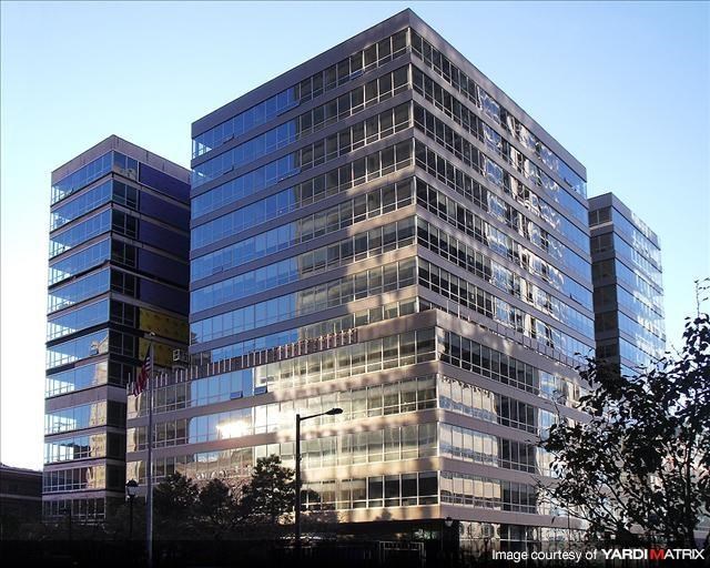 a large glass building with a street lamp in front of it