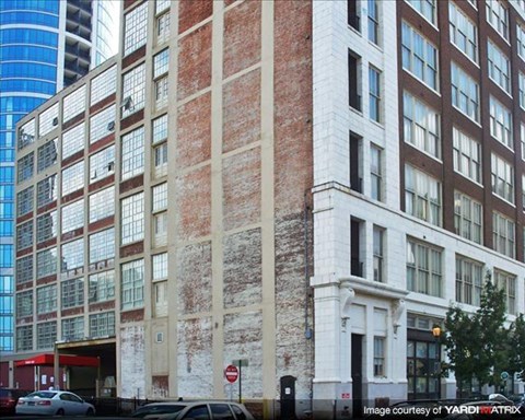a tall brick building with cars parked in front of it