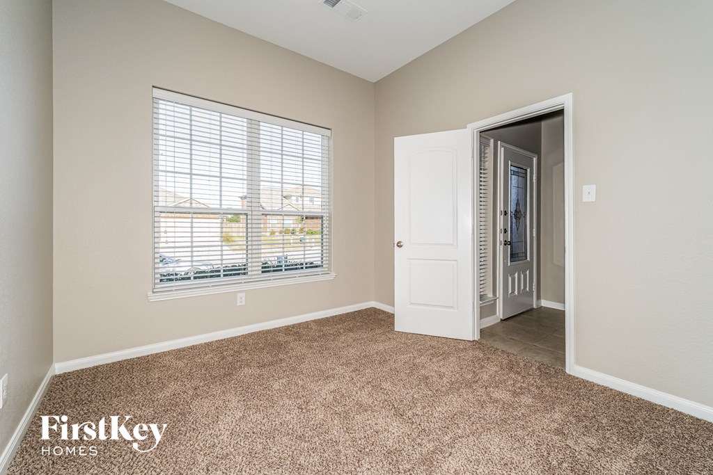 a bedroom with a large window and a door to a closet