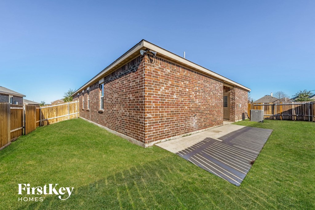 a backyard with a brick building and a wooden fence
