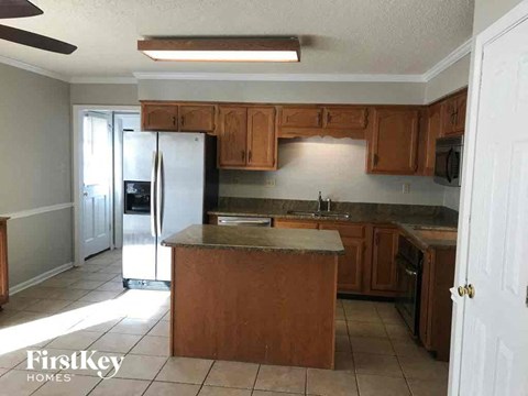 A kitchen with wooden cabinets and a refrigerator.