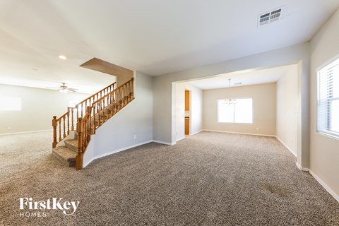 an empty living room with a staircase in a house