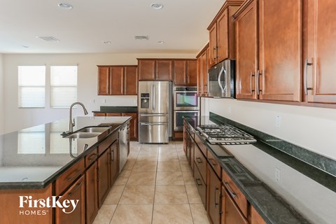 A kitchen with brown cabinets and a stainless steel refrigerator.