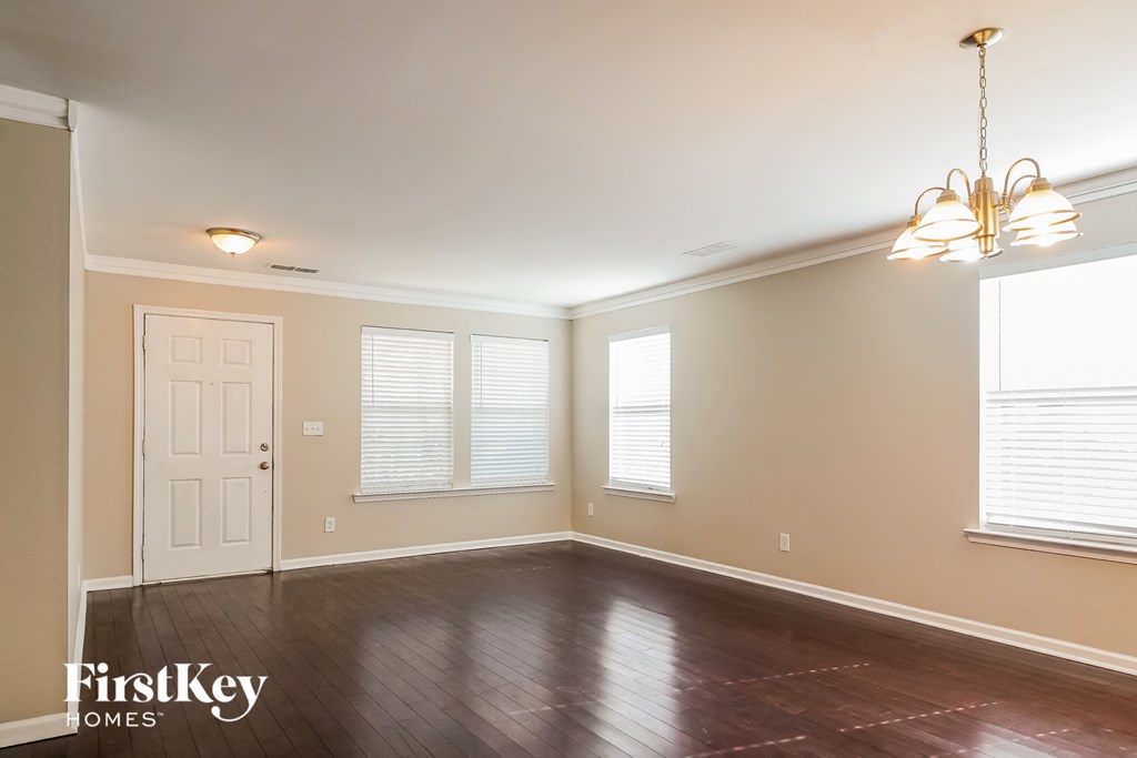 the dining room of an empty house with a chandelier