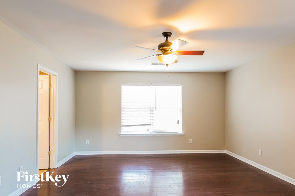 a empty room with a ceiling fan and a window