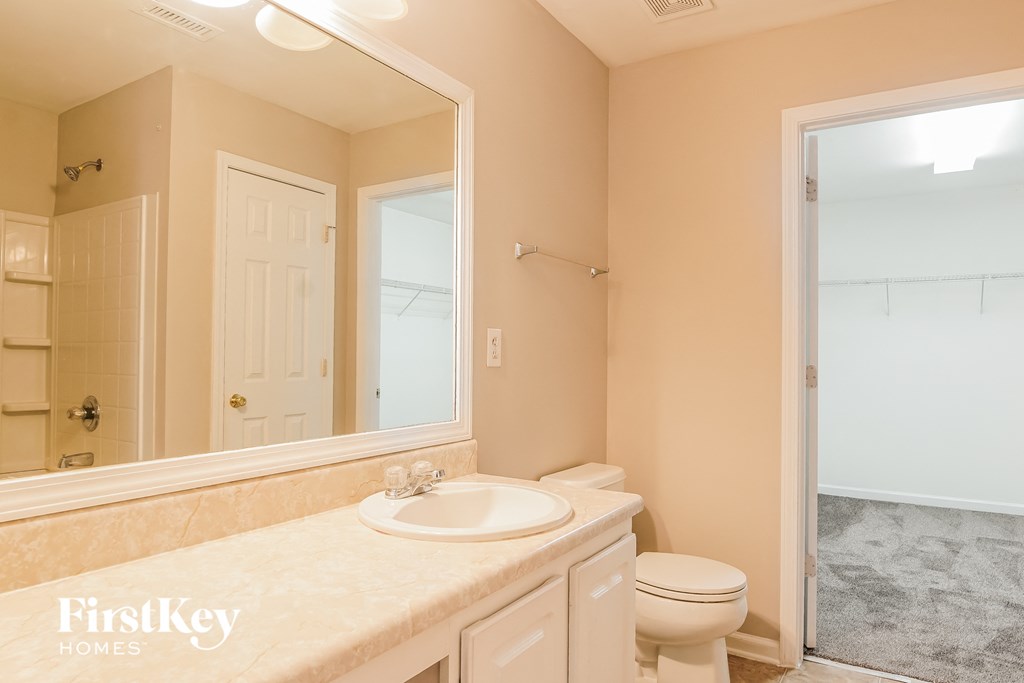 a bathroom with a sink toilet and a mirror