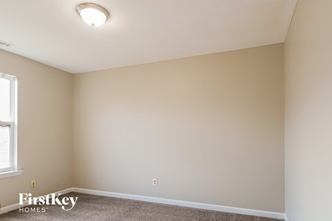the living room of a new home with white walls and carpet