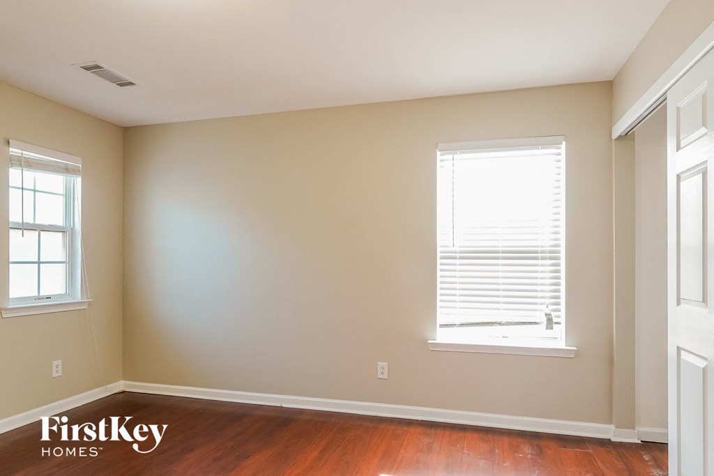 an empty room with a window and wooden floors