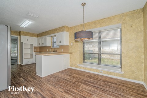 a kitchen with a large window and a white counter top