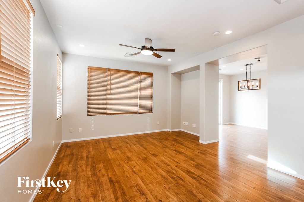 a living room with a wood floor and a ceiling fan