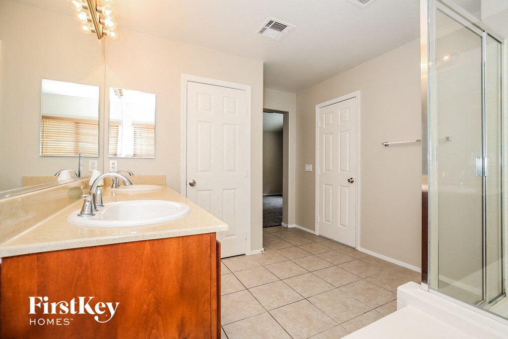 a bathroom with a sink and a shower and a mirror