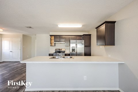 a kitchen with a white counter top and a stainless steel refrigerator