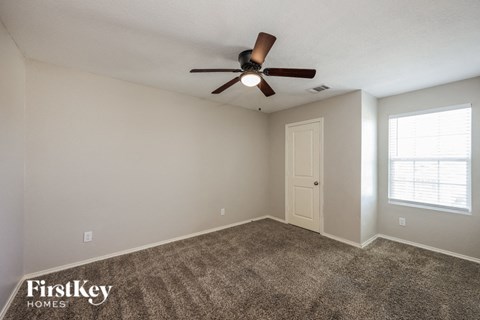 the spacious living room has carpet and a ceiling fan