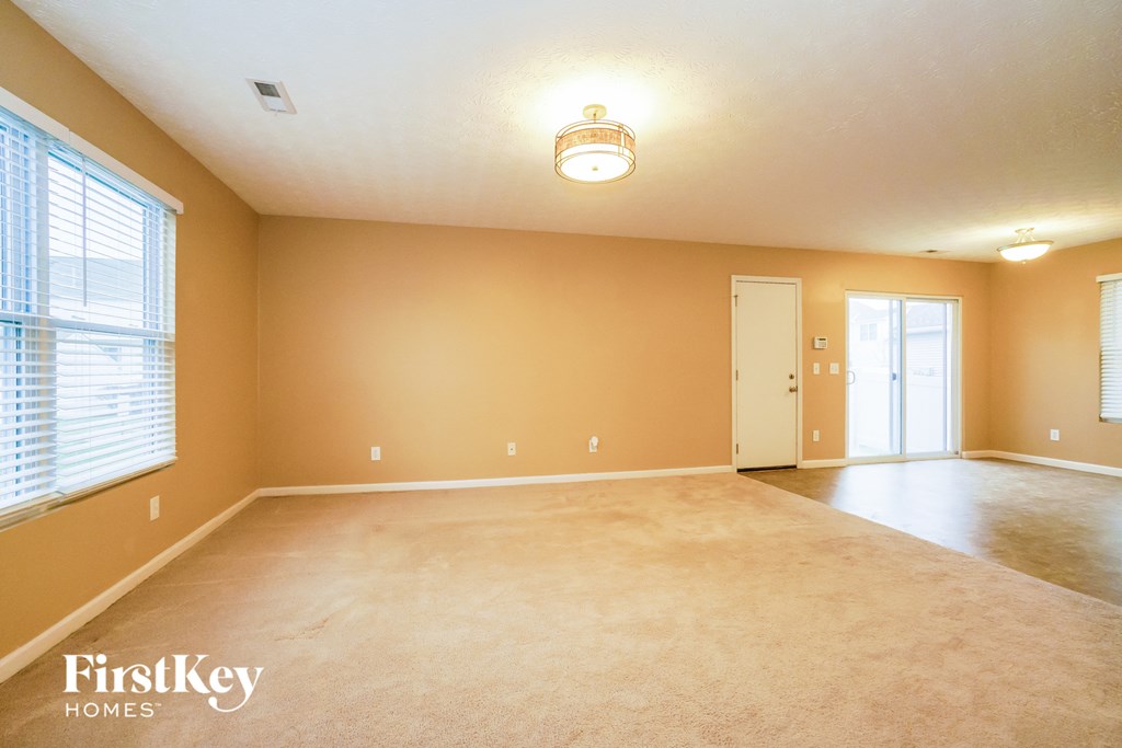 the living room and dining room of an empty house